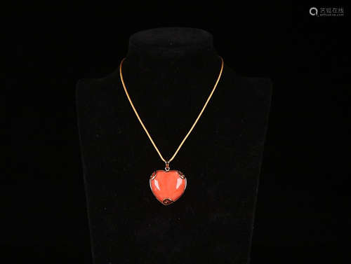 A RED CORAL HEART-SHAPED PENDANT WITH 18K GOLD EMBEDDED