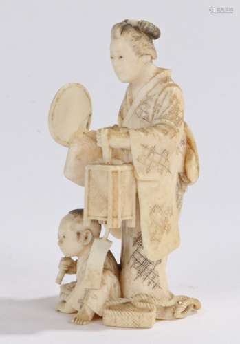 Japanese Meiji period ivory okimono, carved as a standing lady holding a fan above a boy seated on