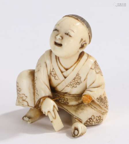 Japanese Meiji period ivory okimono, of a boy crouching holding a block, signed to the base, 4cm