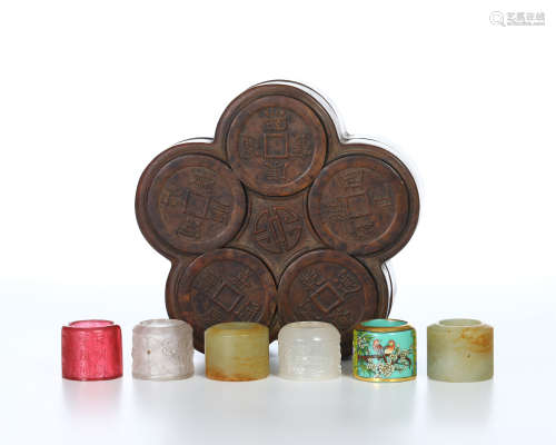 SIX CHINESE PEKING GLASS JADE ARCHER'S RINGS IN ROSEWOOD CASE