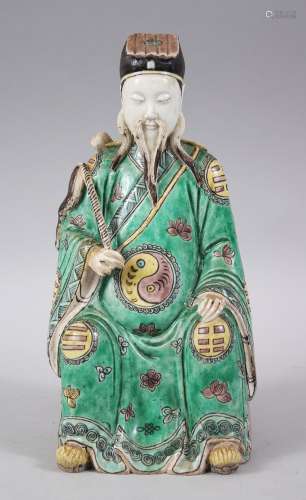 A 19TH / 20TH CENTURY CHINESE FAMILLE VERTE PORCELAIN FIGURE OF AN OFFICIAL, in a seated position