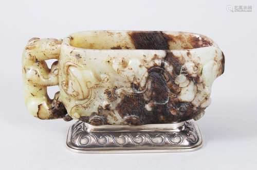 A CHINESE 18TH CENTURY CARVED JADE LIBATION CUP, the sides carved with animals and scrolls, on a