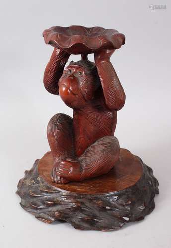 A JAPANESE MEIJI PERIOD CARVED WOOD MONKEY OKIMONO, the monkey carved in a seated position holding a