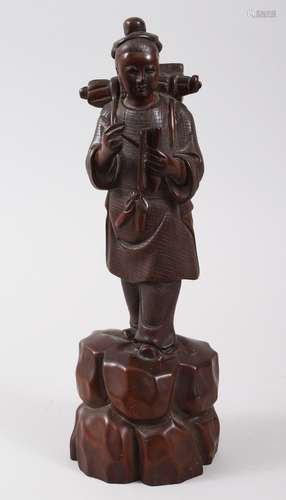 A GOOD CHINESE 19TH CENTURY HARDWOOD FIGURE OF A BOY, modeled holding a quill and scroll, his pack