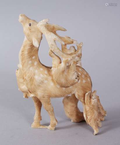 A JAPANESE MEIJI PERIOD CARVED IVORY OKIMONO OF MONKEY AND STAG, the stag modeled with five