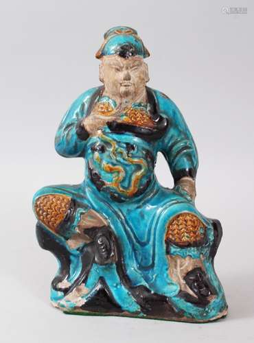 A GOOD CHINESE MING PERIOD TURQUOISE POTTERY FIGURE OF GUANDI, modeled in a seated position upon a