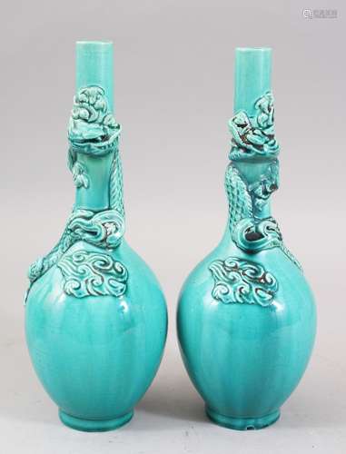 A PAIR OF ORIENTAL TURQUOISE GROUND PORCELAIN DRAGON BOTTLE VASES, both vase with moulded dragons