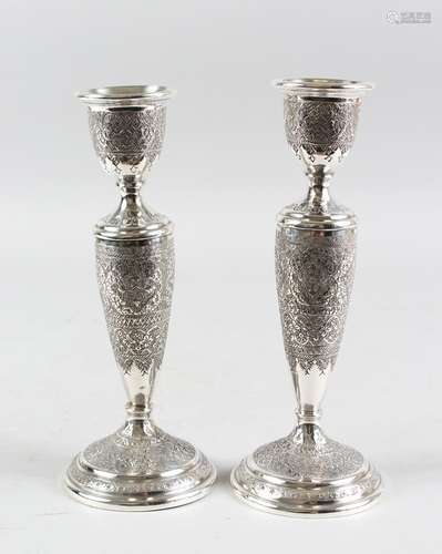 A PAIR OF PERSIAN WHITE METAL CANDLESTICKS, 19cm high.