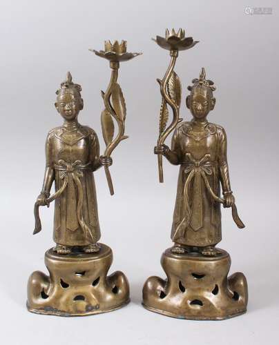 A PAIR OF 20TH CENTURY ORIENTAL / THAI BRONZE CANDLESTICKS, depicting two figures holding lotus