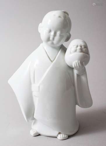 A JAPANESE MEIJI PERIOD HIRADO PORCELAIN FIGURE OF A BOY AND DARUMA, the boy holding a daruma