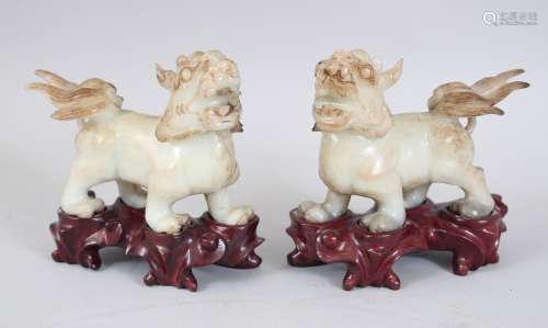 A PAIR OF 20TH CENTURY CHINESE JADE / SOAPSTONE LION DOGS ON STANDS, the pair of fo dogs on fitted