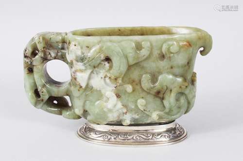 A CHINESE 18TH CENTURY CARVED JADE LIBATION CUP, the sides carved with animals and scrolls, on a