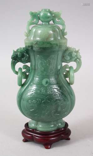 A 20TH CENTURY CHINESE CARVED JADE LIDDED VASE & STAND, the vase with a lion dog handled lid, with