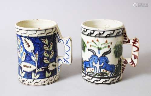 TWO IZNIK STYLE POTTERY TANKARDS, 13cm high.