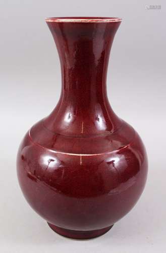 A 19TH / 20TH CENTURY CHINESE OX BLOOD RED PORCELAIN BOTTLE VASE, 33cm high x 20cm wide.