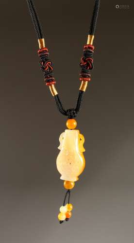 A CARVED CHINESE STONE PENDANT on a rope.