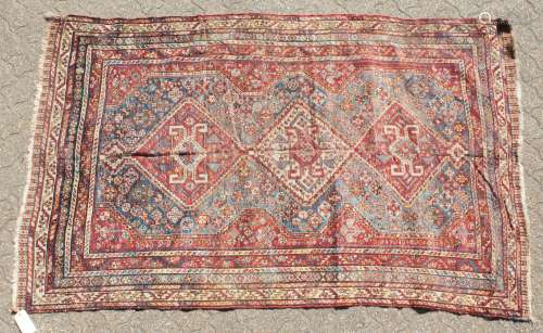 A LARGE OLD PERSIAN SHIRAZ RUG with three main diamond shaped motifs. 7ft 4ins x 4ft 8ins.