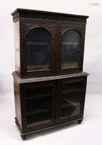 A GOOD 19TH CENTURY ANGLO INDIAN PADAUK WOOD CUPBOARD BOOKCASE, with lancet carved cornice, a pair