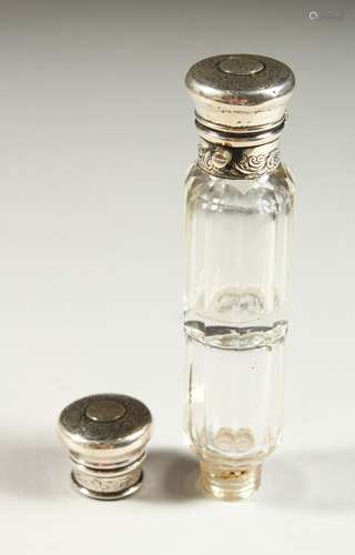 A VICTORIAN DOUBLE ENDED GLASS SCENT BOTTLE, the silver caps engraved with scrolls and with