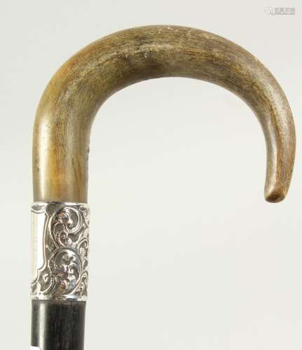 A WALKING STICK with Rhino curving handle and silver band. Circa 1900. 2ft 6ins long.