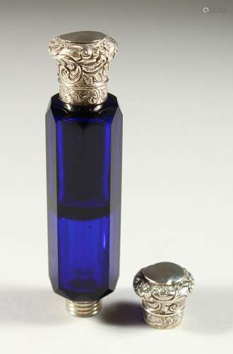 A VICTORIAN BRISTOL BLUE GLASS FACET CUT DOUBLE ENDED SCENT BOTTLE with repousse silver caps.