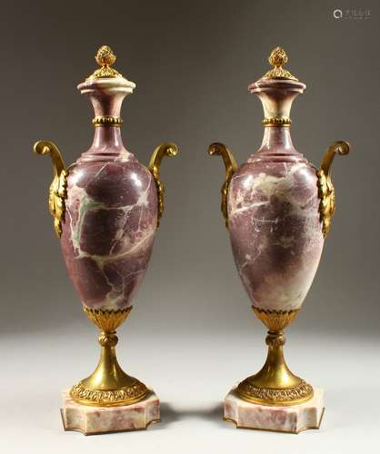 A GOOD PAIR OF VIOLET MARBLE AND ORMOLU MOUNTED VASE SHAPED URNS, each with pineapple finials,