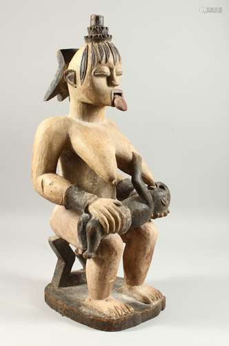 A LARGECARVED WOOD TRIBAL FIGURE, seated mother and baby, with white pigment decoration. 60cms