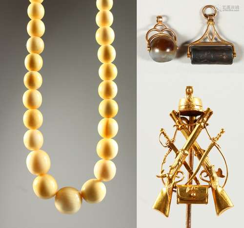 AN EARLY 20TH CENTURY IVORY BEAD NECKLACE, a gilt metal military stick pin and two fob seals.