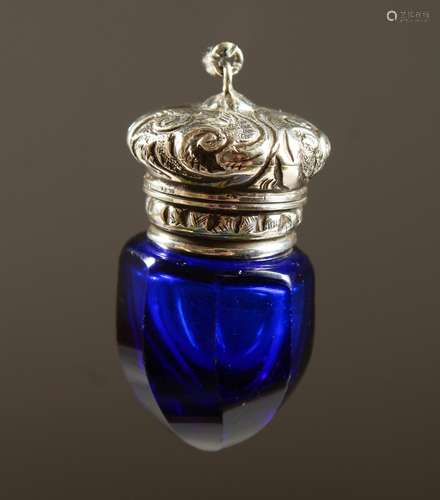 A SMALL BRISTOL BLUE GLASS FACET CUT SCENT BOTTLE with silver top. 4cms long.