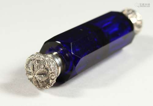 A VICTORIAN BRISTOL BLUE GLASS FACET CUT DOUBLE ENDED SCENT BOTTLE with repousse silver caps.