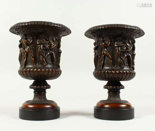 A VERY GOOD PAIR OF BRONZE CAMPAGNA VASES on black marble bases, the borders with classical figures.