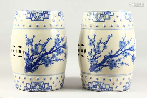 A PAIR OF CHINESE BLUE AND WHITE BARREL SEATS with almond blossom design. 1ft 6ins high.