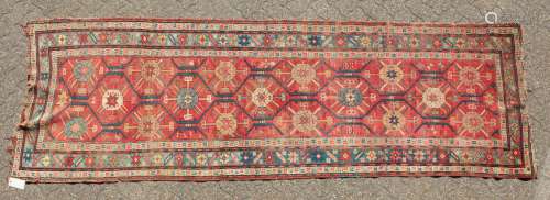 A CAUCASIAN RUNNER with typical motifs in red and blue. 10ft 9ins x 3ft 6ins.