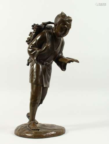 A LARGE 19TH CENTURY JAPANESE BRONZE FIGURE OF A MAN, faggotson his head and carrying a book.