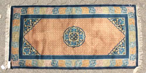 A CHINESE WOOL RUG with central motif and patterned border. 4ft 7ins x 2ft 3ins.