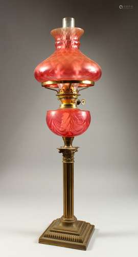 A GOOD VICTORIAN BRASS CORINTHIAN COLUMN LAMP with ruby glass bowl. 2ft 4ins high.