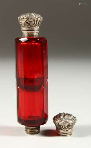 A VICTORIAN RUBY FACET CUT DOUBLE ENDED SCENT BOTTLE with repousse silver caps. 10cms long.