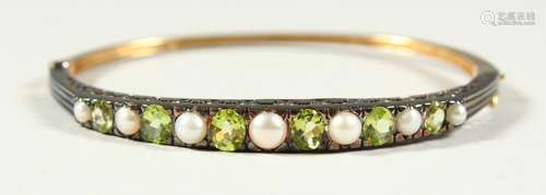 A 9CT GOLD, PERIDOT AND PEARL BANGLE, boxed.