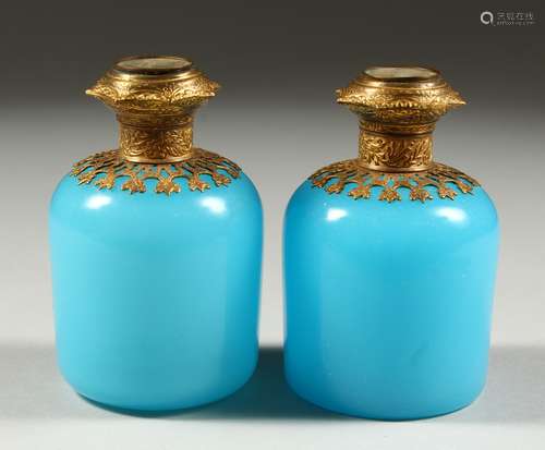 A PAIR OF 19TH CENTURY FRENCH BLUE OPALINE SCENT BOTTLES with gilt mounts, the tops with scenes of