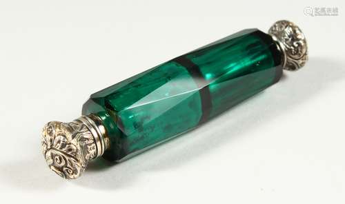 A VICTORIAN CUT GREEN GLASS DOUBLE ENDED SCENT BOTTLE with repousse silver tops. 12.5cms long.