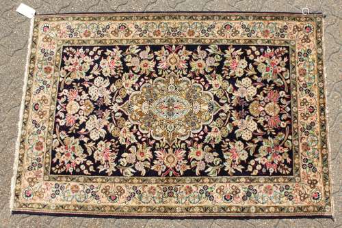 A FINE PERSIAN QUM SILK RUG, the centre with a pattern of flowers on a blue ground, within a