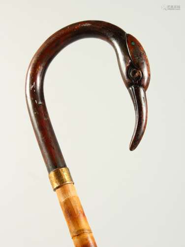 A SLENDER WALKING STICK with carved bird handle. 2ft 9ins long.