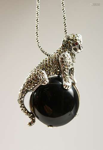 A SILVER ONYX PANTHER PENDANT BROOCH on a chain.