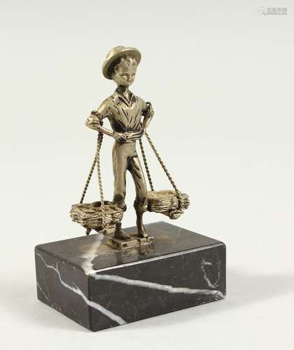 A SMALL CONTINENTAL SILVER FIGURE OF A MAN carrying two baskets, on a marble base. 3.5ins high.