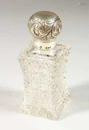 A VICTORIAN SHAPED CUT GLASS SCENT BOTTLE AND STOPPER with screw off repousse silver top. London