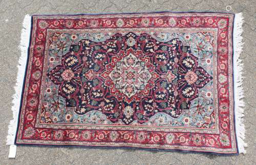 A GOOD PERSIAN SAROUK WOOL RUG with a large central motif on a blue ground with flower motifs on a