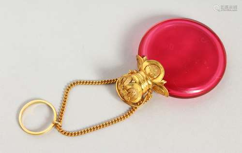 A 19TH CENTURY RUBY GLASS CIRCULAR SCENT BOTTLE with gilt cap and chain. 4.5cms diameter.