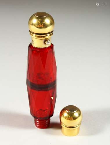 A VICTORIAN FACET CUT RUBY GLASS DOUBLE ENDED SCENT BOTTLE with gilt tops. 13cms long.