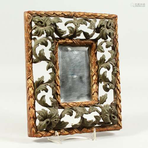 A SMALL FLORENTINE MIRROR, with carved, pierced, gilded and painted frame. 26cms x 21cms.