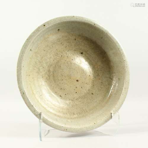 A LARGE PLAIN CIRCULAR CELADON SHALLOW BOWL. 13. ins diameter